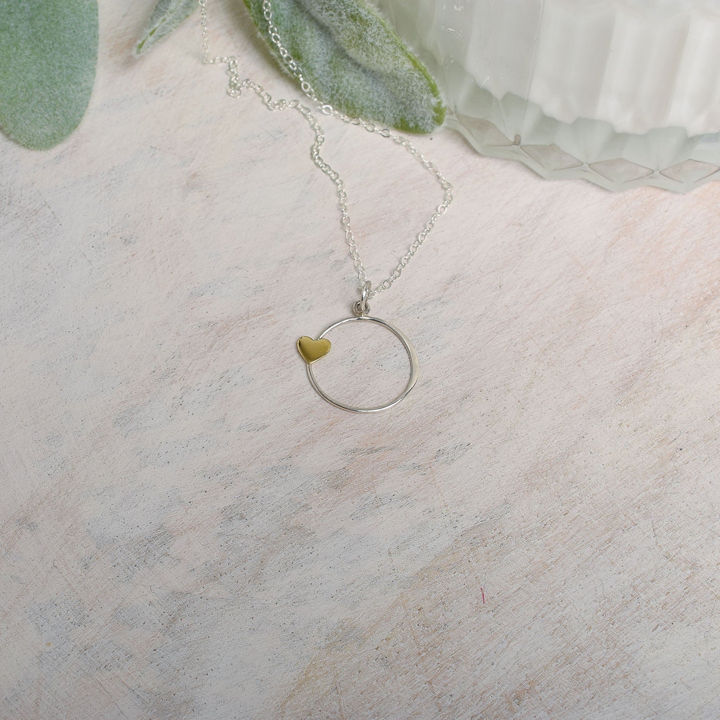 Necklace with a heart pendant on a light wood surface