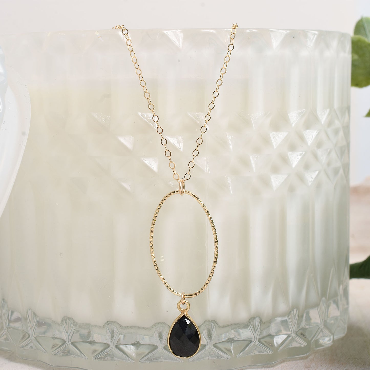 Gold-filled oval pendant accented by a black spinel bezeled gemstone