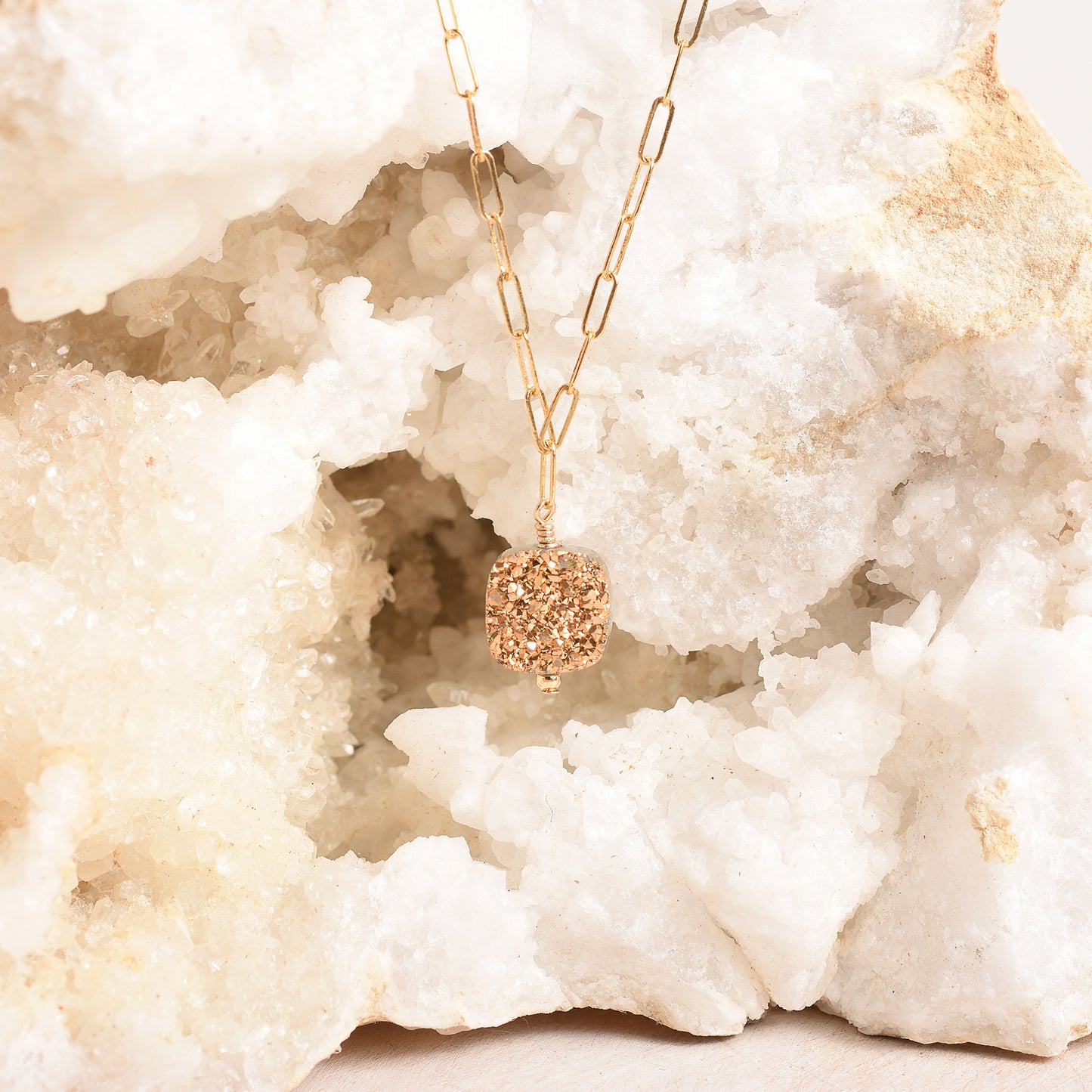 Square druzy pendant suspended from a geode
