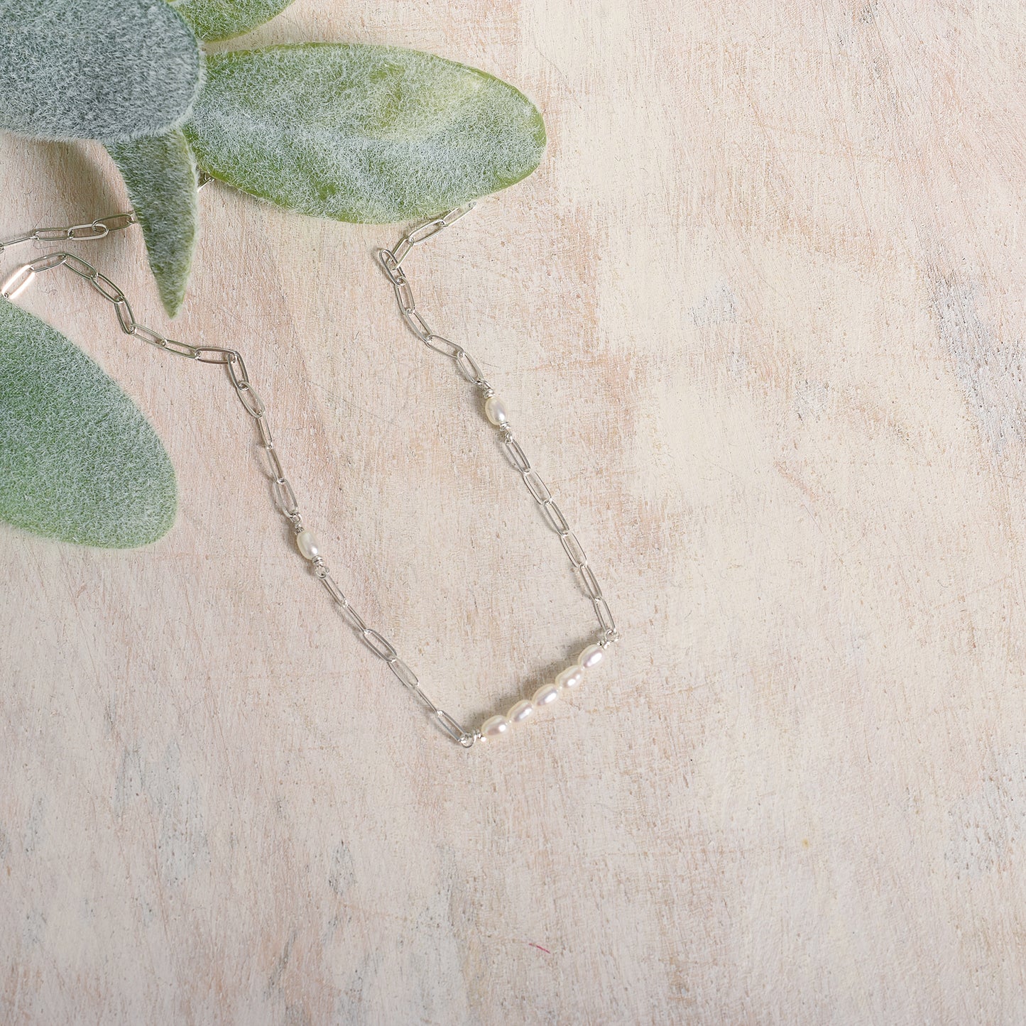 Silver paperclip necklace on a light background
