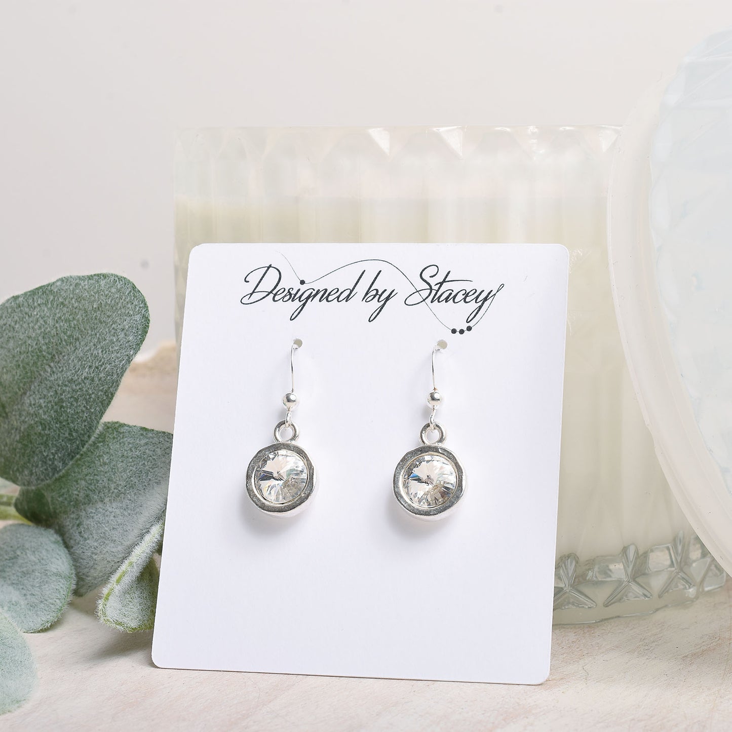 Silver earrings on an earring card with a light background