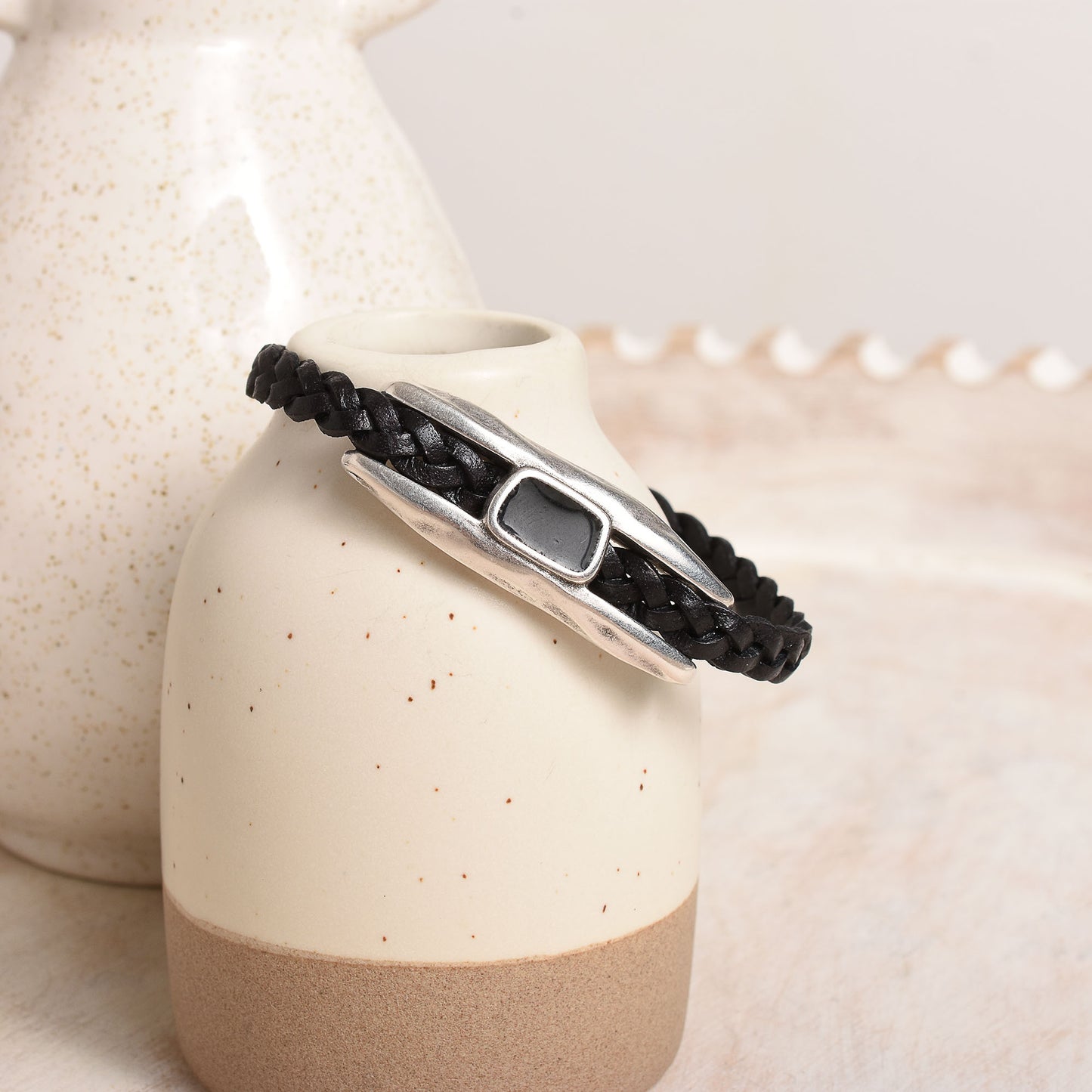 Black leather braided bracelet with silver rectangular form.