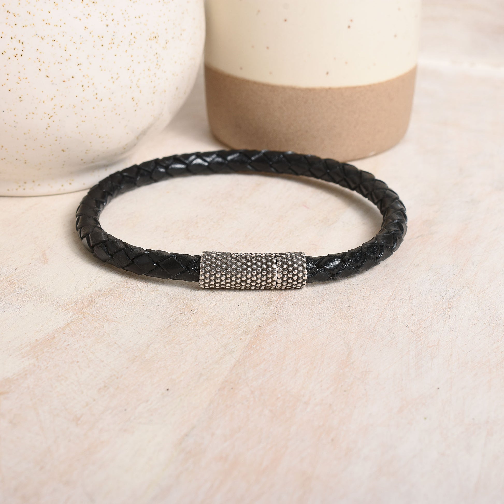 Round braided leather in black with a dotted silver clasp.