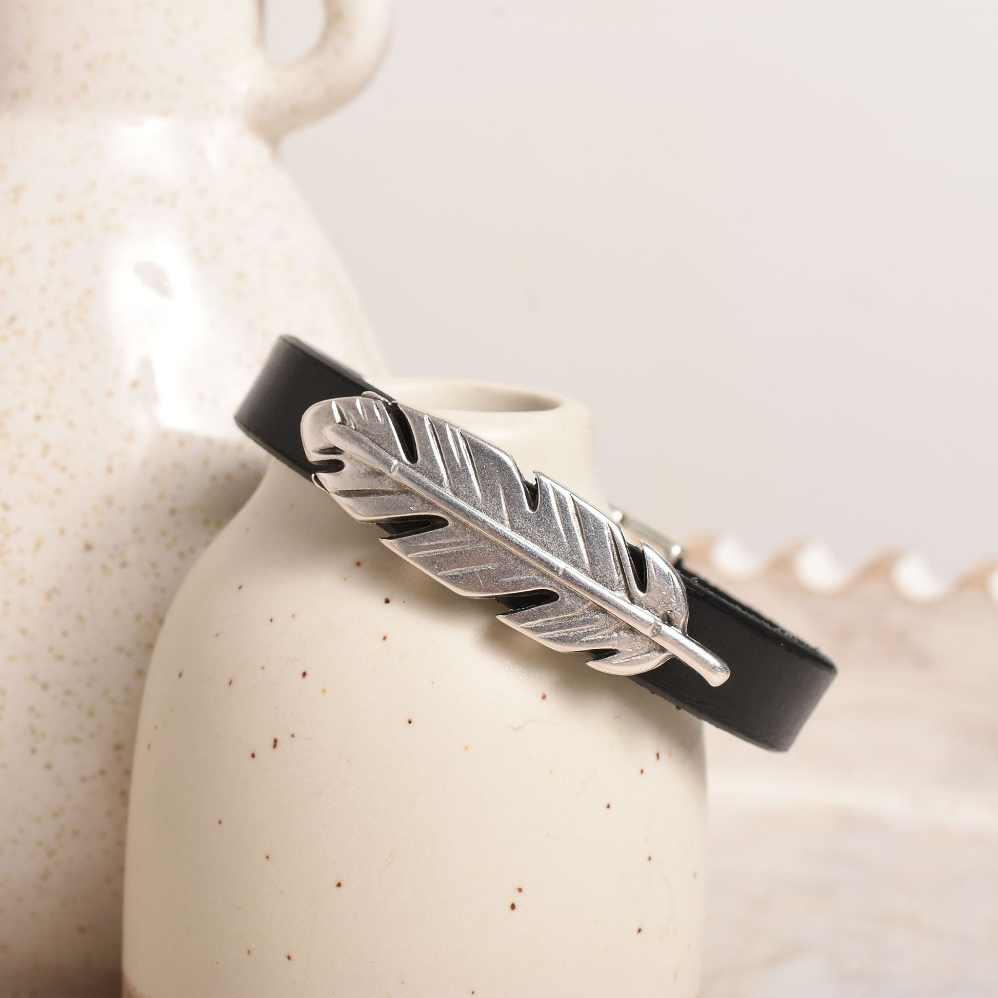 Flat black leather with a silver feather slider bead.