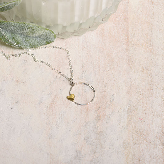 Necklace with a heart-shaped pendant on a textured surface