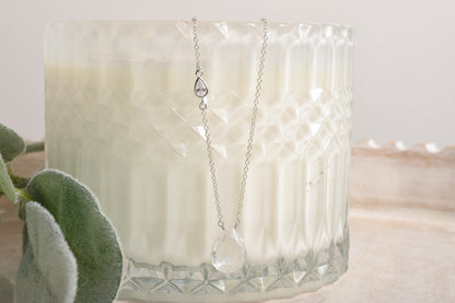 Necklace with a pendant displayed in front of a candle