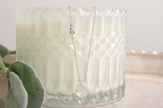 Necklace with a pendant displayed in front of a candle