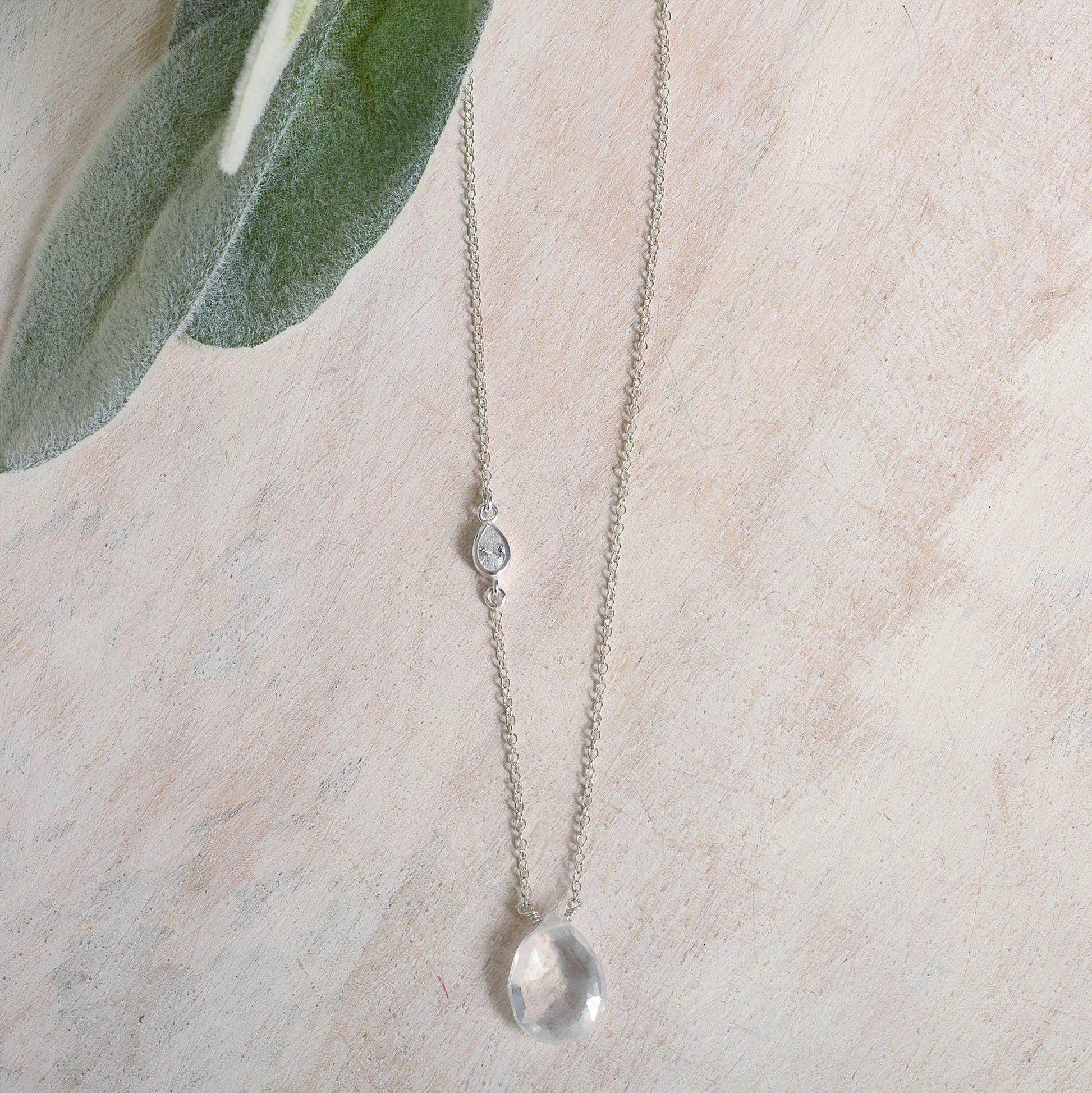 Necklace with a clear quartz pendant on a light background