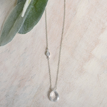 Necklace with a clear quartz pendant on a light background