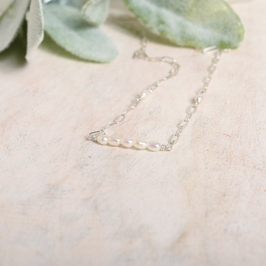 Pearl necklace against a wood background