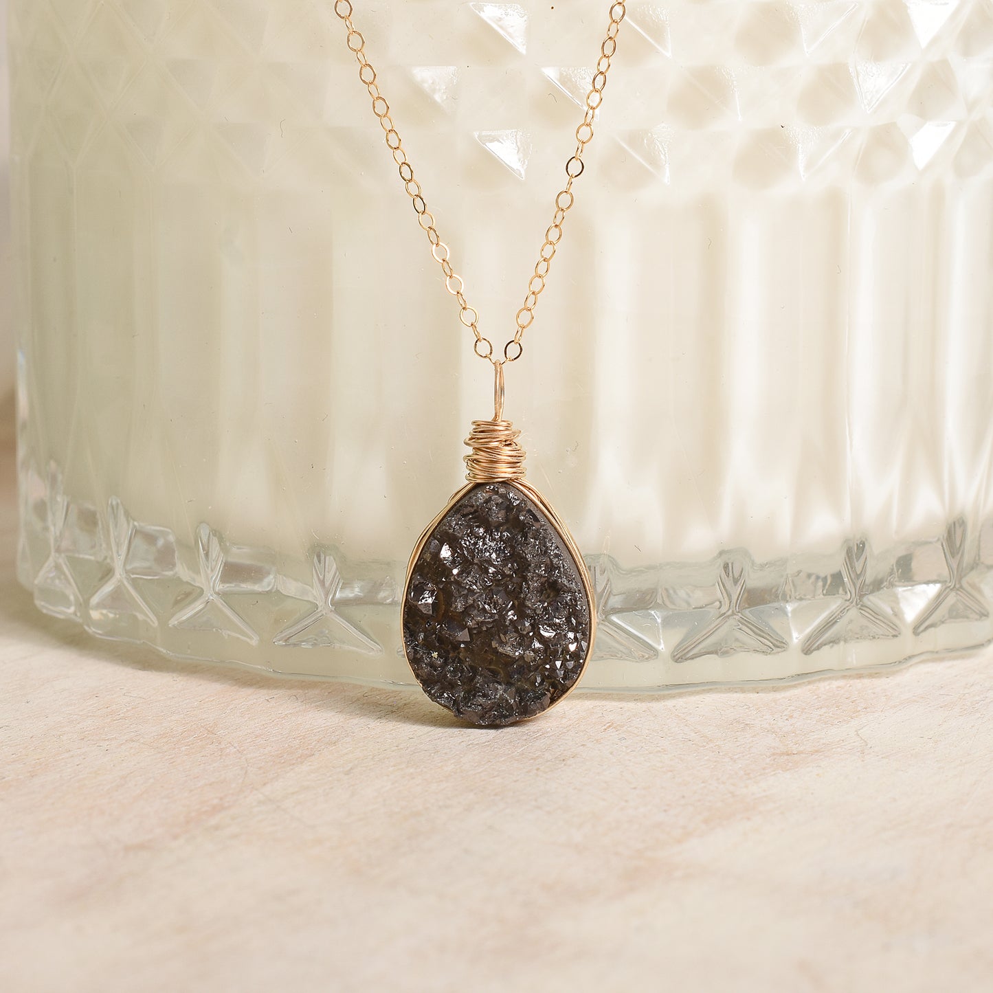 Necklace with a dark stone pendant on a textured surface
