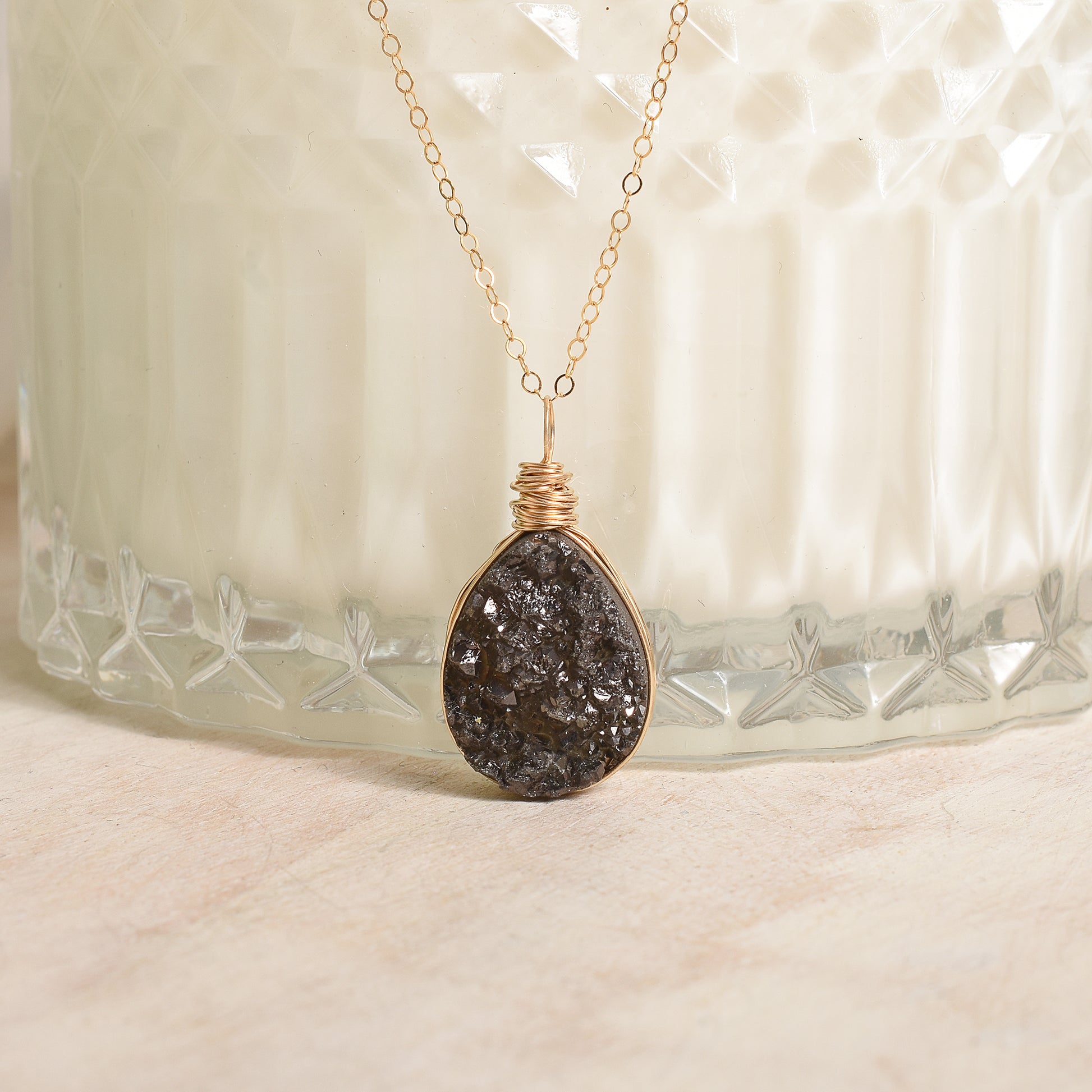 Necklace with a dark stone pendant on a textured surface