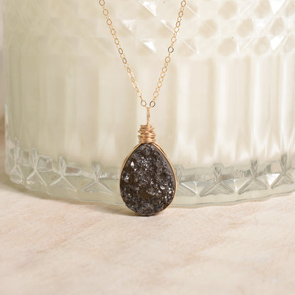 Necklace with a dark stone pendant on a textured surface