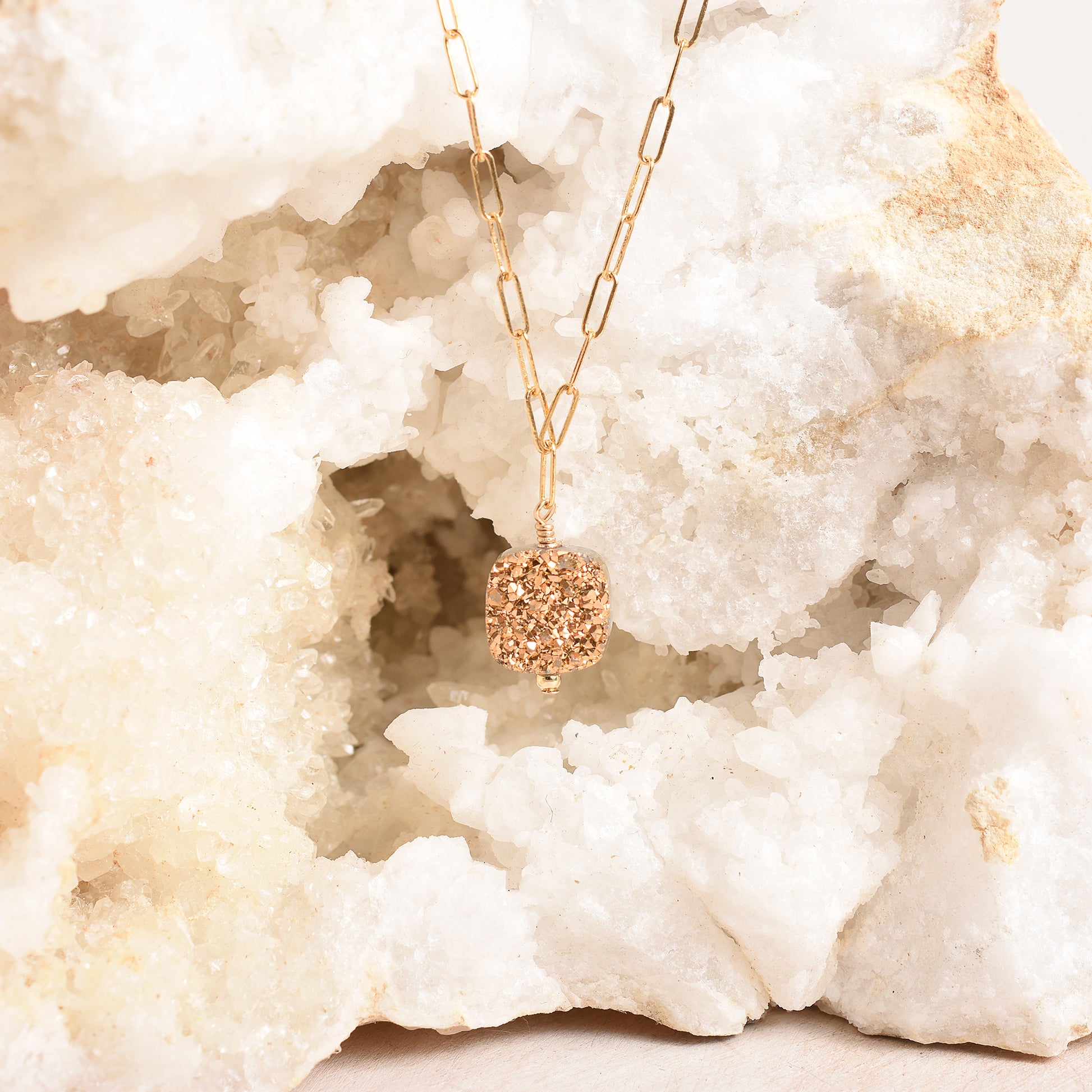 Square druzy pendant suspended from a geode