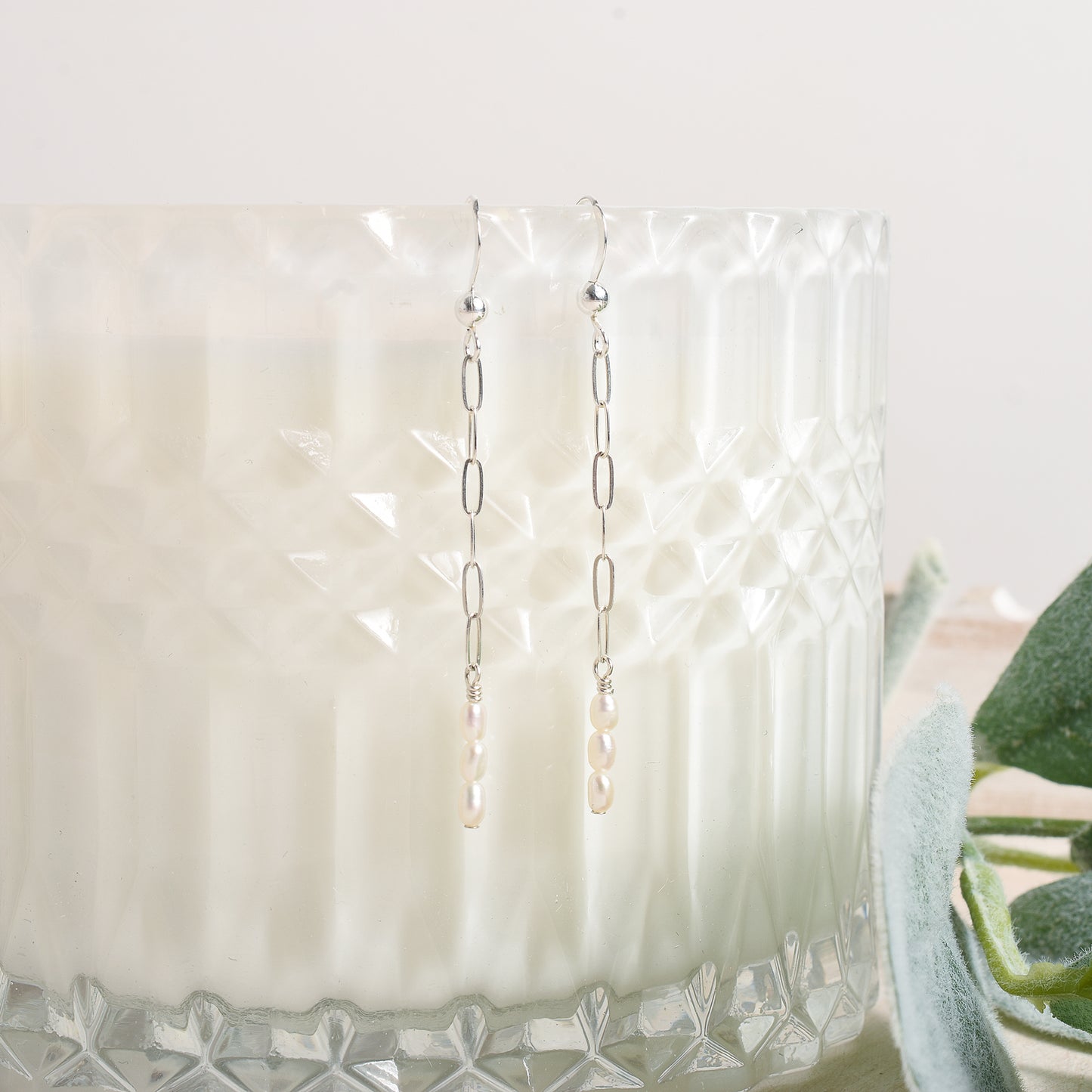 Dangly earrings hanging on a glass