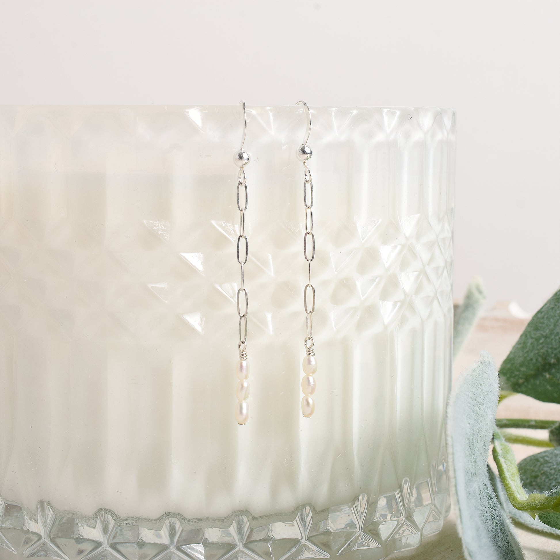 Dangly earrings hanging on a glass