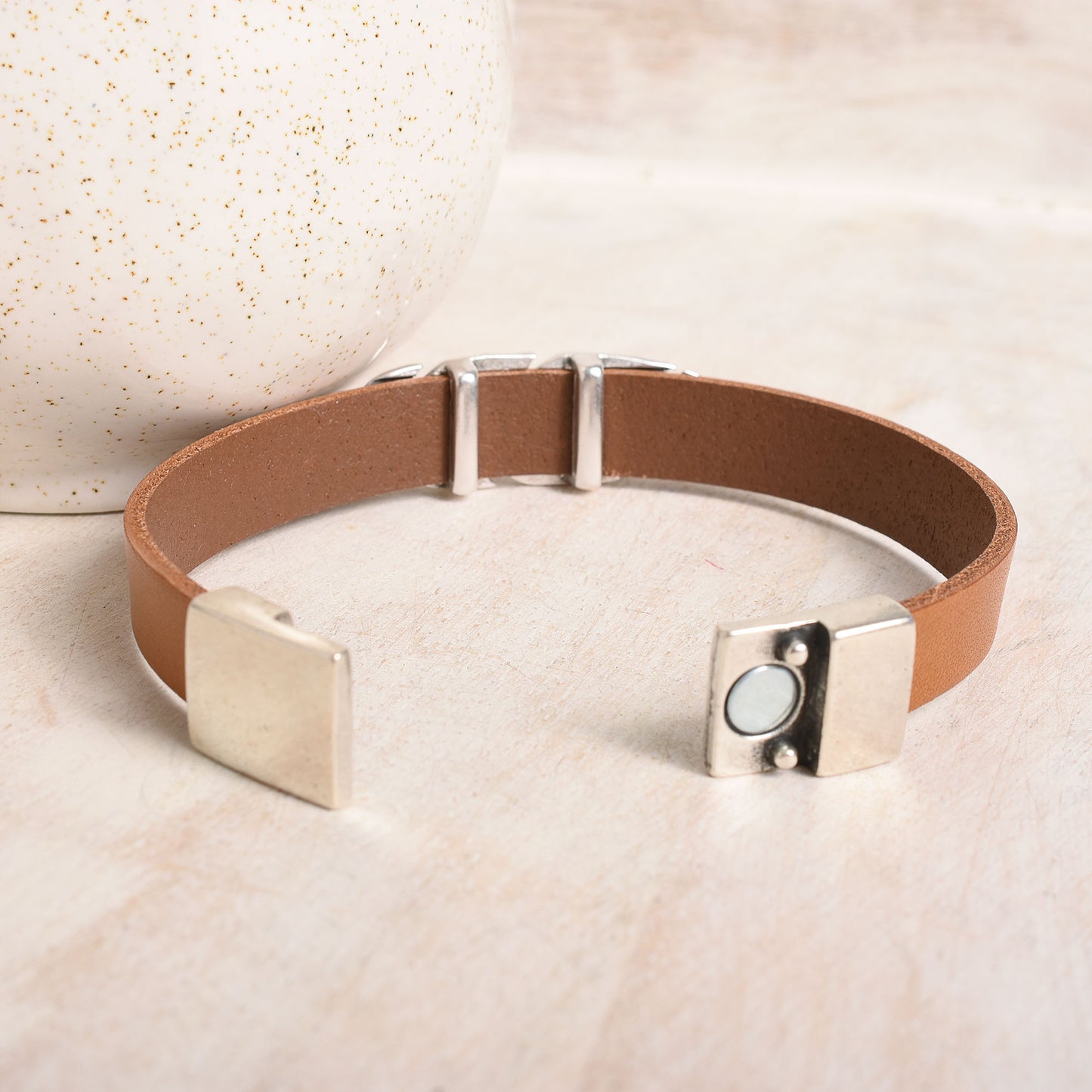 Silver magnetic clasp with a wide tan leather band